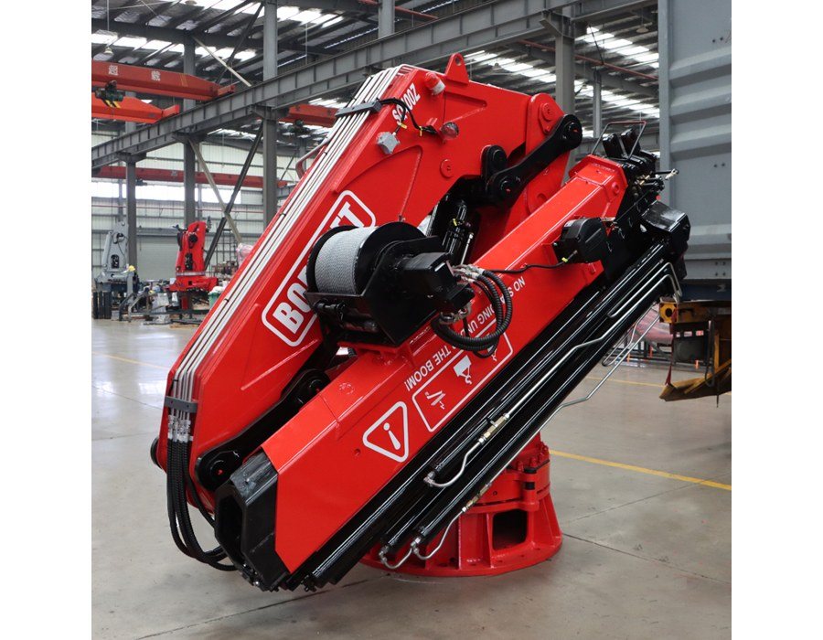 Red BOB-LIFT 20 t Grues marines à flèche articulée standing in the factory with its boom folded in the stowed position and a hoisting winch mounted on the boom